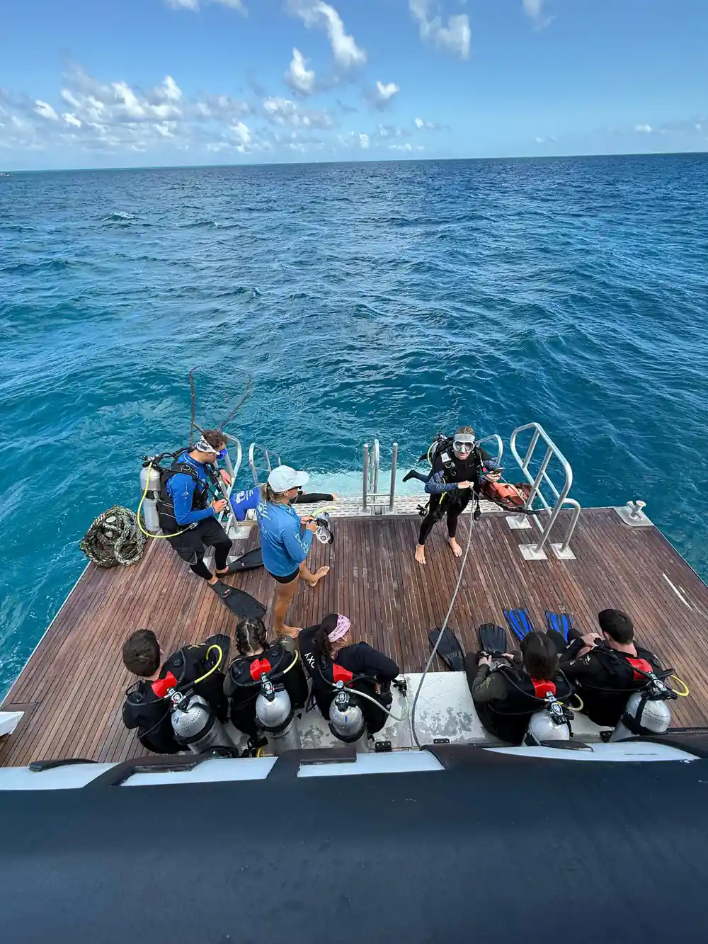 Divers kitted up along the timber dive deck at the stern