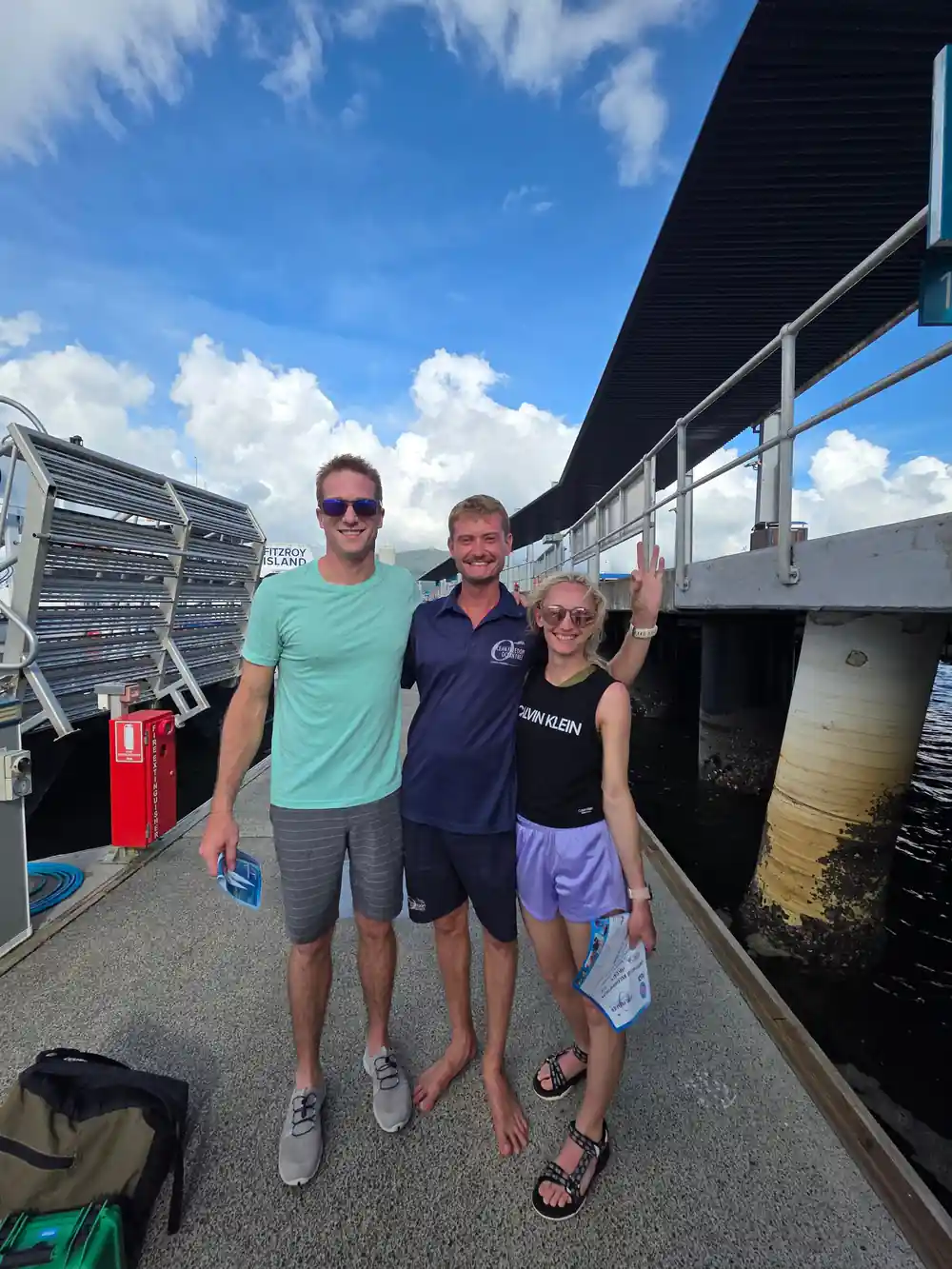 Three guests on the marina walkway before boarding